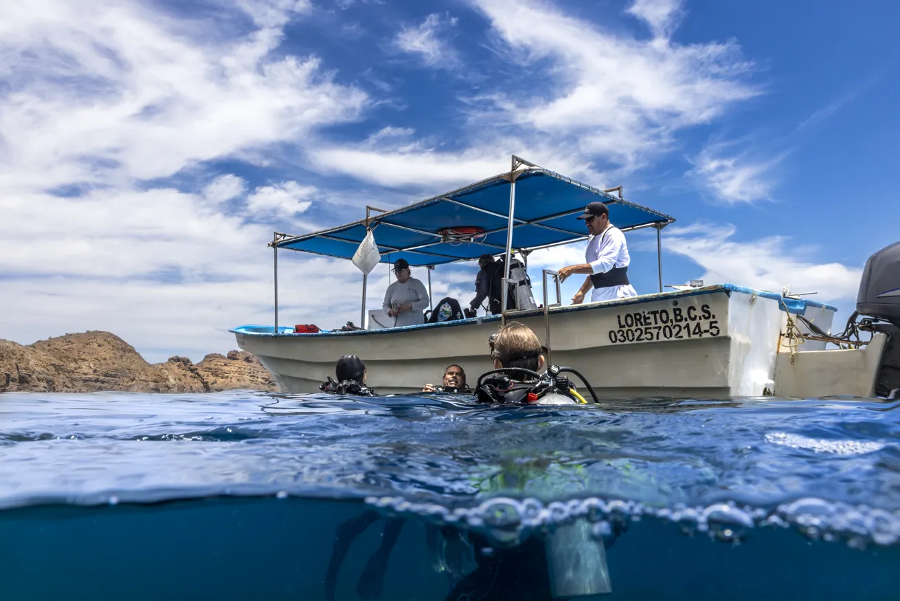 Dive guide Juve chats with Alexis and Theo on the surface.