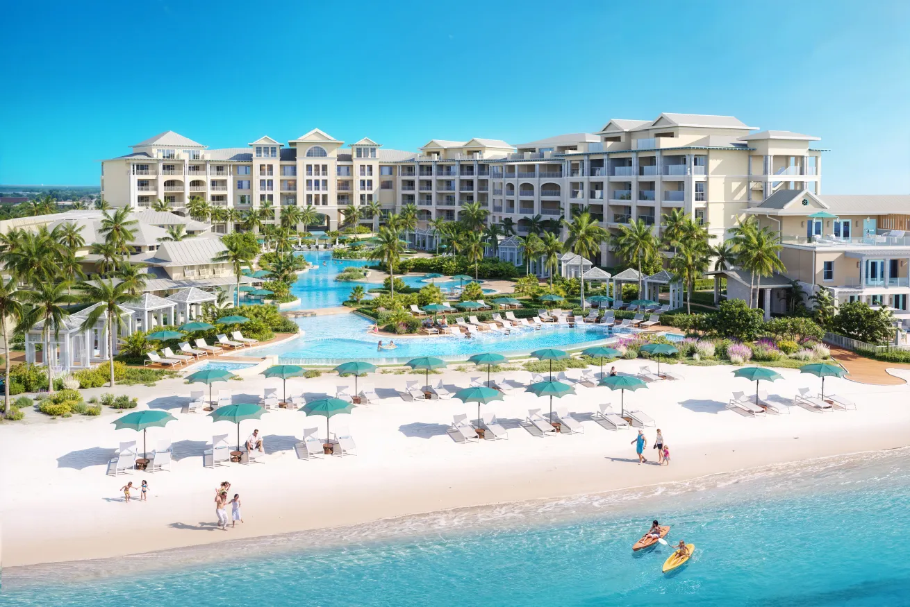 The Treasure Beach village at Beaches resort with a pool and people on the beach in Turks and Caicos
