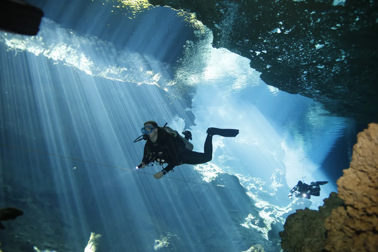 Divers follow a guideline while exploring cenote Kukulkan.