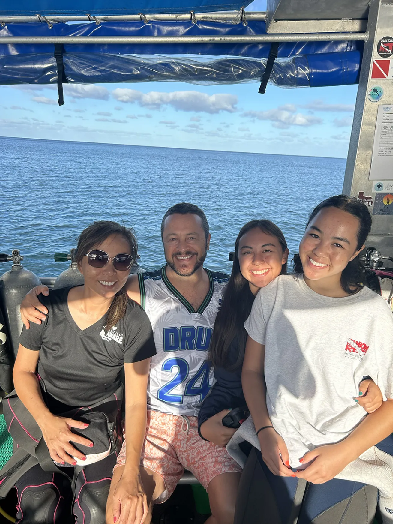 a family siting on a dive boat