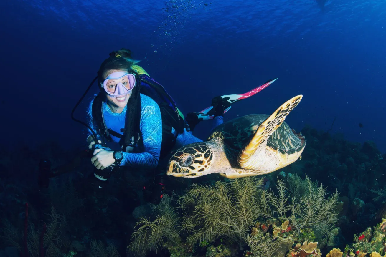 A diver kitted in Spacefish Army gear dives with a turtle.