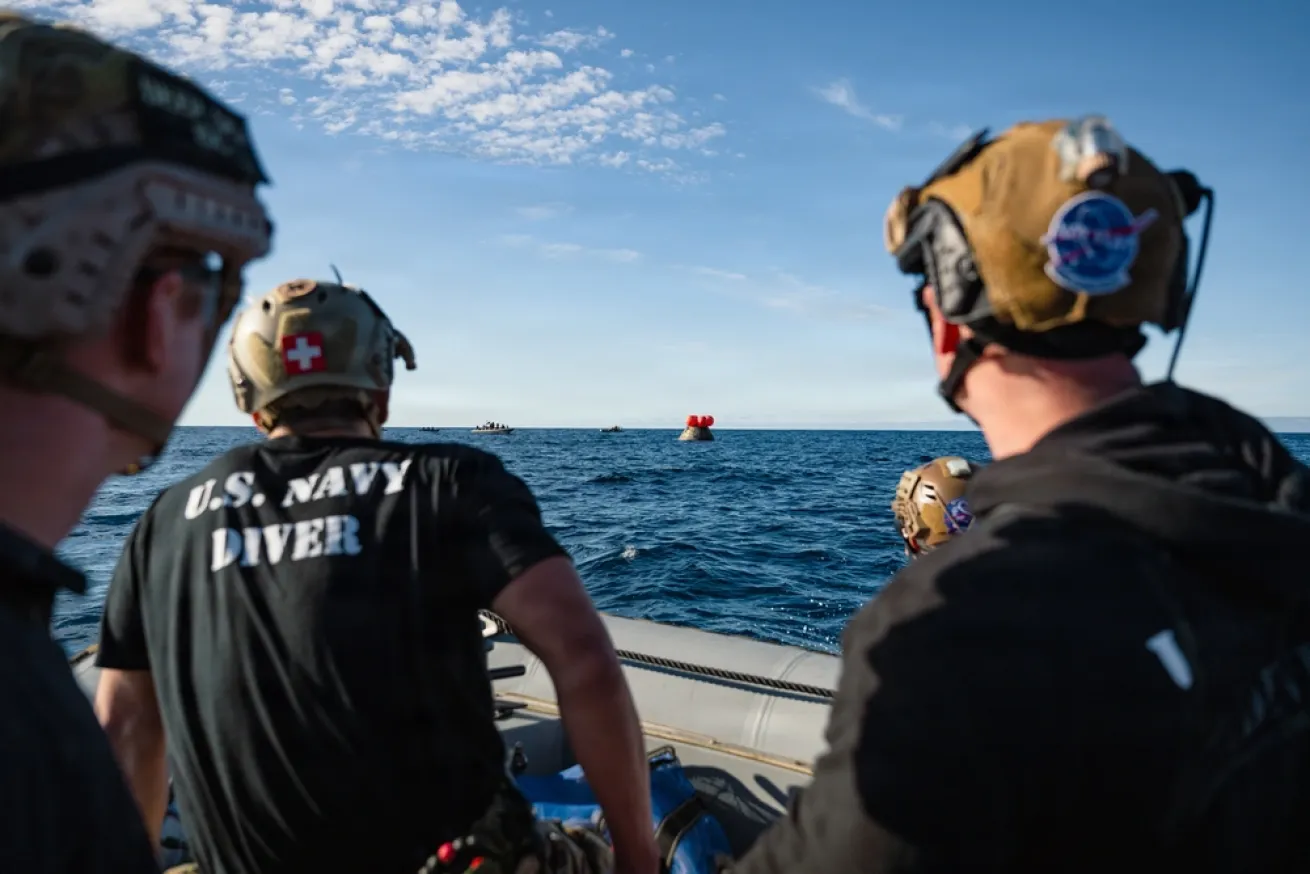 U.S. Navy divers prepare to conduct a hazardous material detection sweep of the Orion space capsule. 