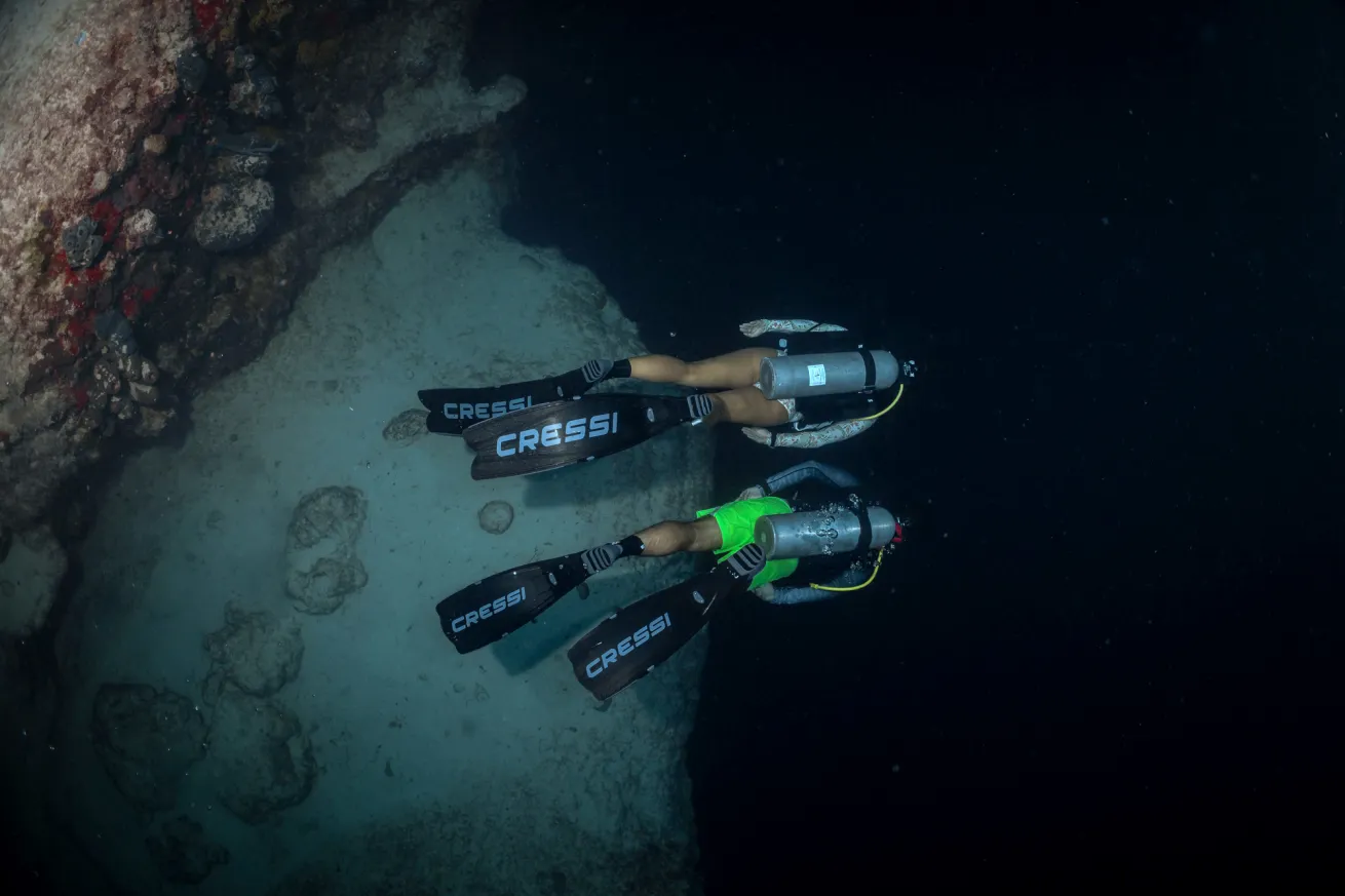 Scuba divers explore a blue hole in the Exumas, Bahamas.