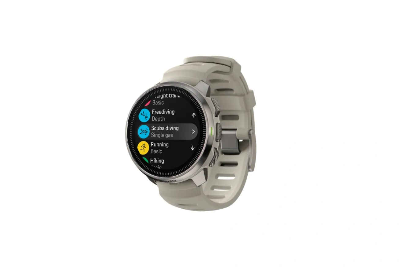 Round smartwatch-style dive computer with a color display showing multiple activity modes, including scuba diving and freediving, on a light-colored strap.