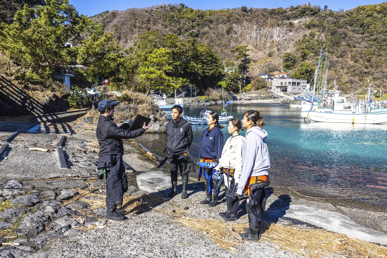 A guide in Futo, Japan, delivers a safety briefing to a group of divers.

