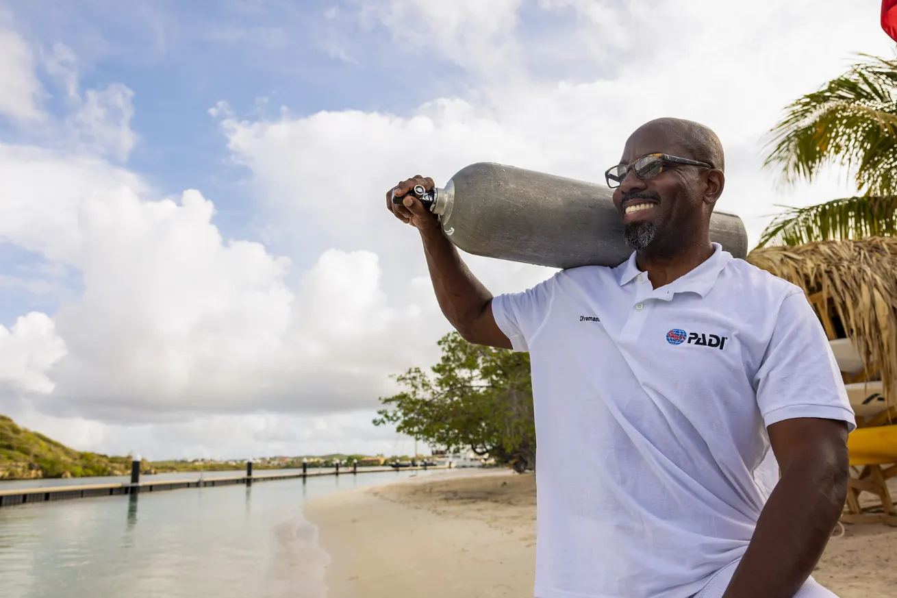 Man holding scuba tank and smiling