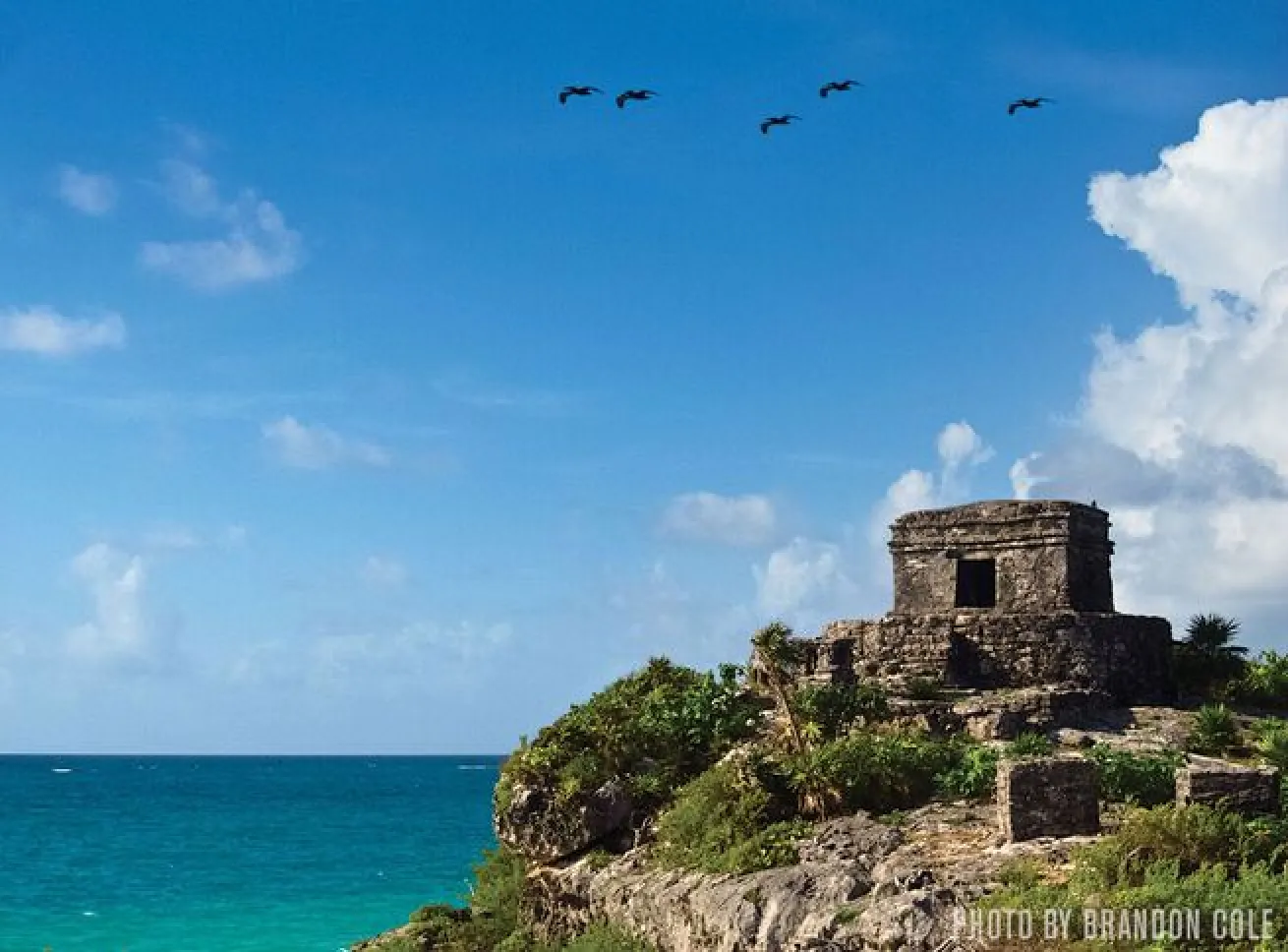 The ancient Mayan ruins of Tulum cling to the cliffs on the coastline.