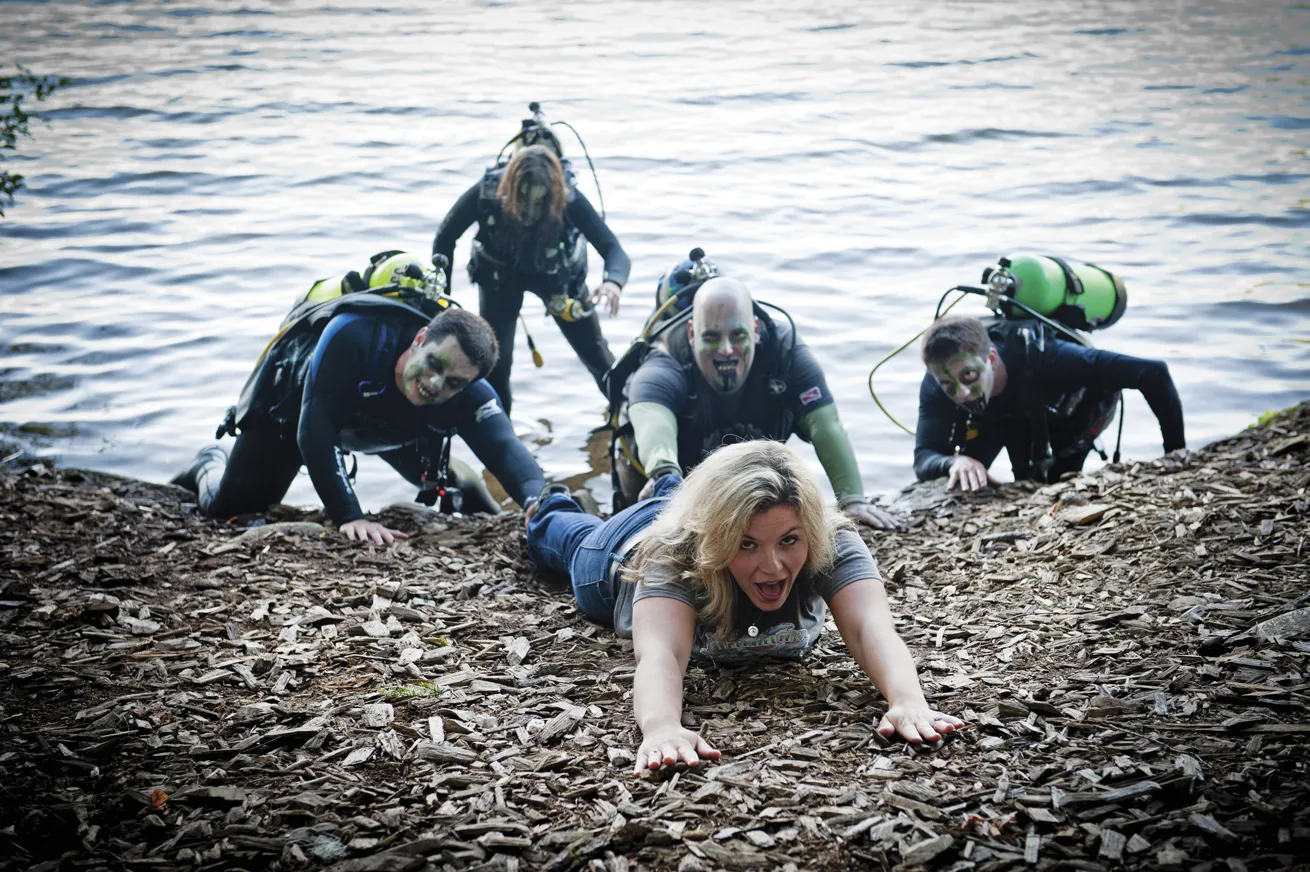 A horde of “zombies,” including Tinsley (center), leans into the theme of the Zombie Apocalypse Diver distinctive specialty. Note that the course does not include being pulled into the water by zombies.
