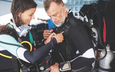 two_divers_gearing_up_and_conducting_a_predive_safety_check_edit.jpg.webp