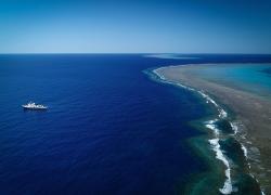 R/V Falkor floating near Ribbon Reef #5 in the Great Barrier Reef.