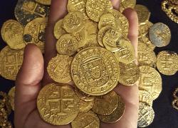 Piles of recovered gold coins salvaged from shipwrecks